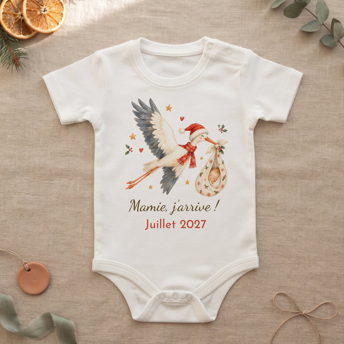 Body annonce grossesse cigogne de Noël avec le message Mamie, j'arrive ! Juillet 2027