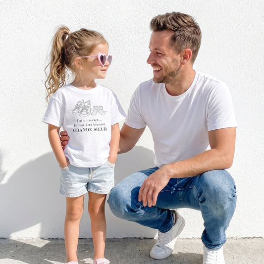 Père et sa fille portant le t-shirt annonce grande sœur pour révéler une grossesse