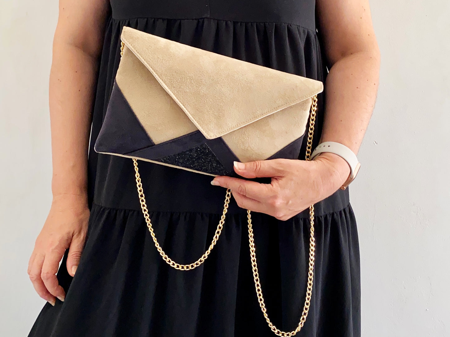 pochette femme noire et beige portée avec robe noire