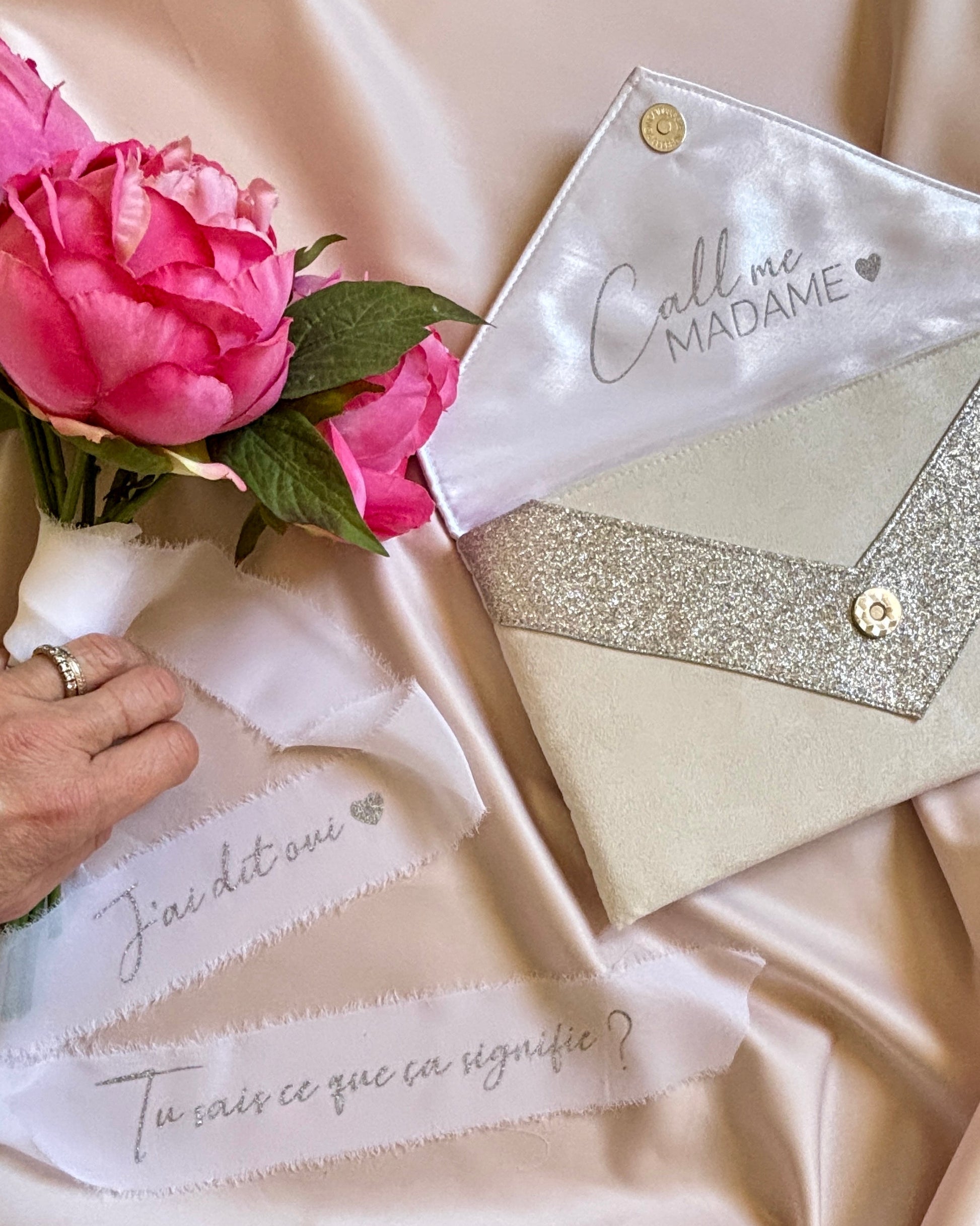 Détail écriture personnalisée argentée sur ruban de soie blanc mariage