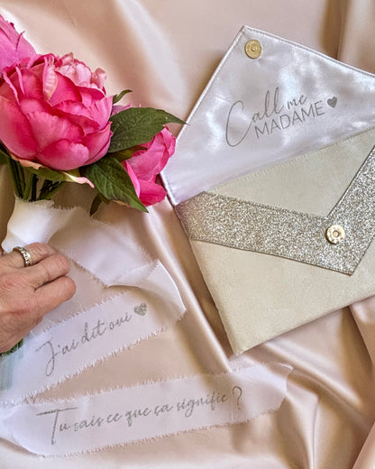 Détail écriture personnalisée argentée sur ruban de soie blanc mariage