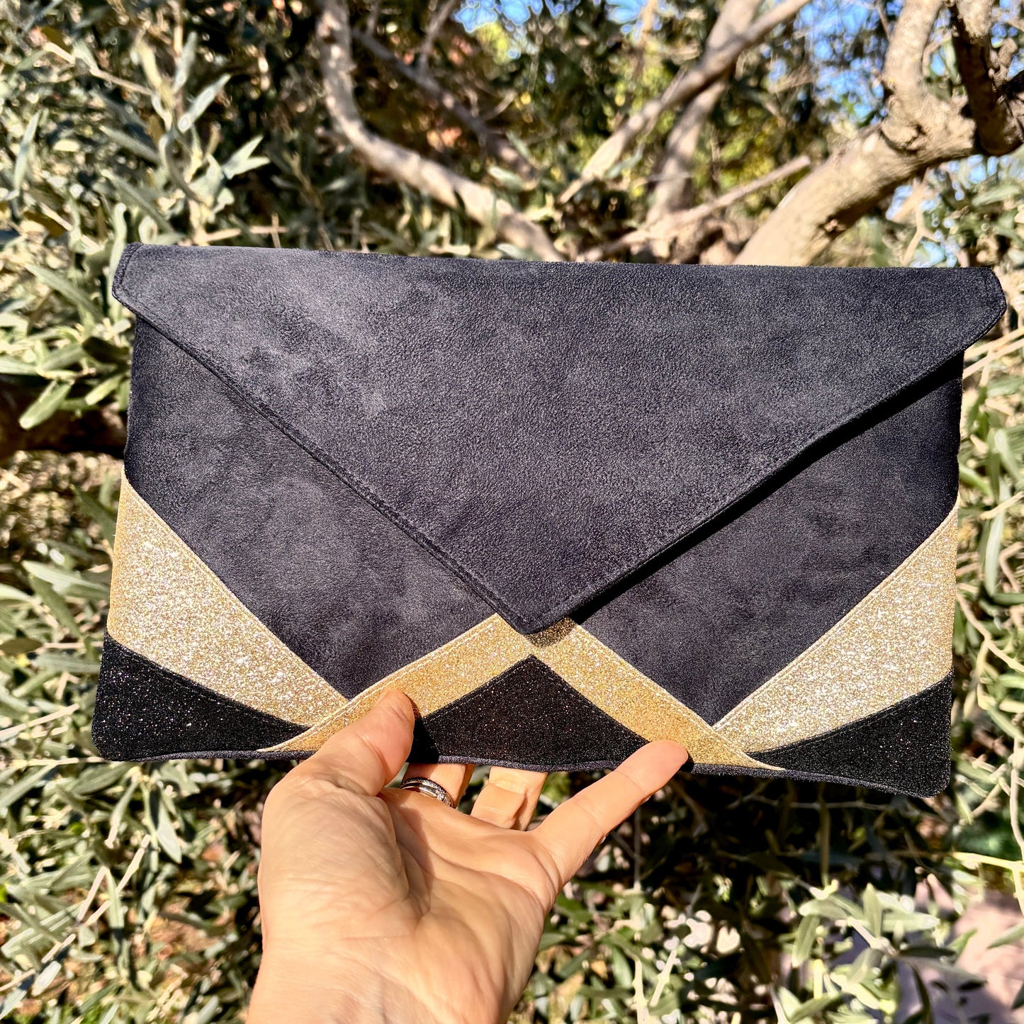Pochette enveloppe noire suédine avec détails dorés graphiques