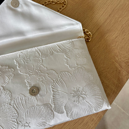 gros plan sur le tissu brocart blanc fleuri texturé de la pochette mariage