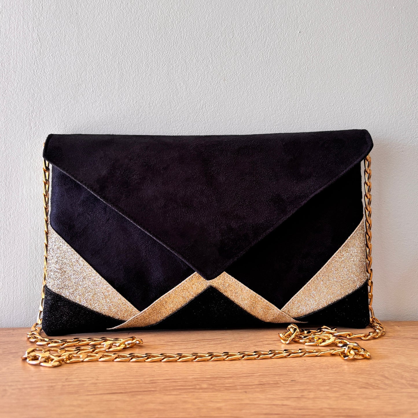 Pochette de soirée forme enveloppe en suédine noire et paillettes dorées avec chaîne dorée