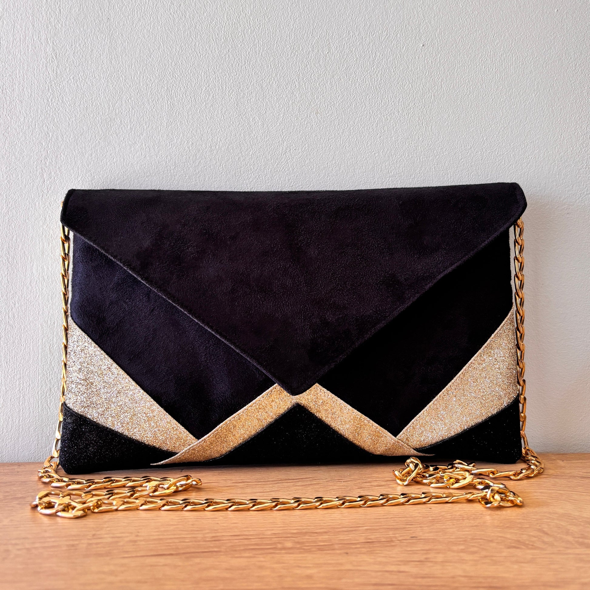 Pochette de soirée forme enveloppe en suédine noire et paillettes dorées avec chaîne dorée