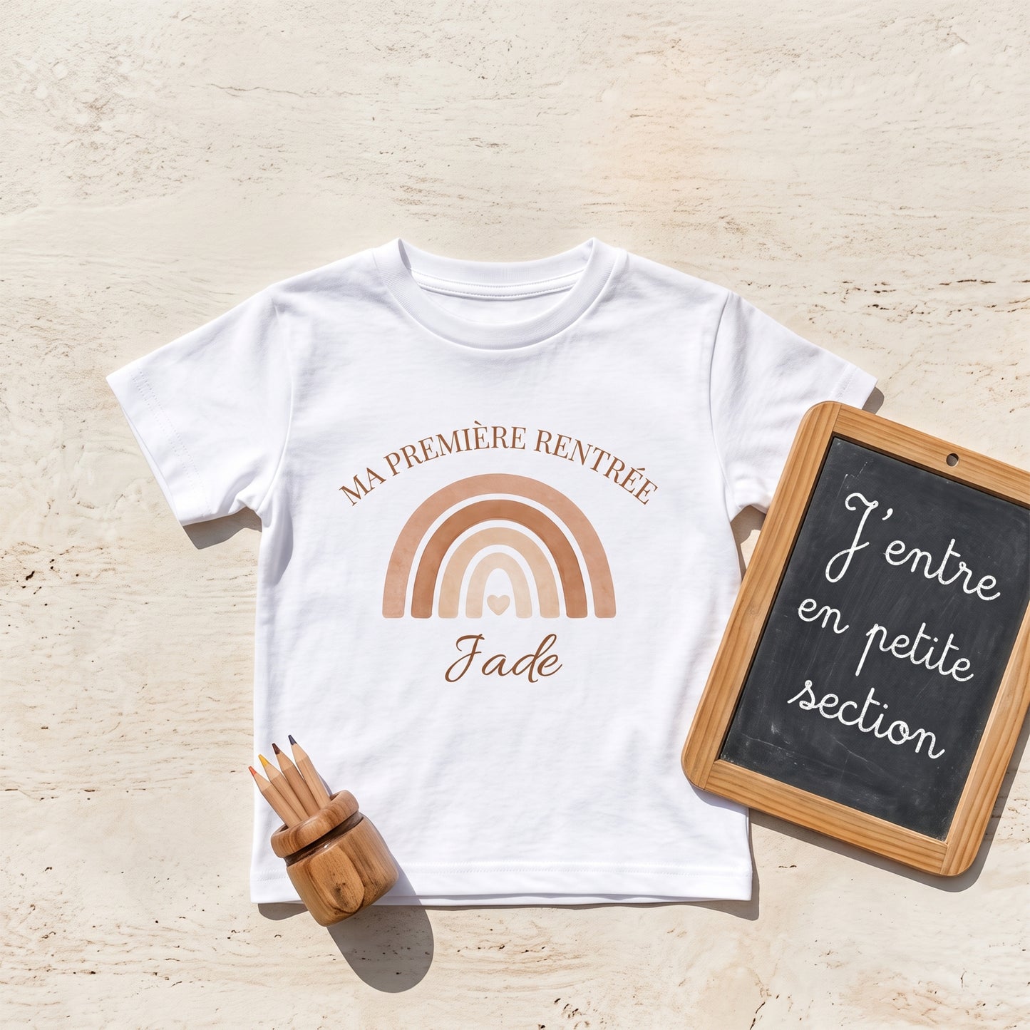 T-shirt personnalisé rentrée scolaire posé avec ardoise J'entre en petite section, crayons et arc-en-ciel terracotta