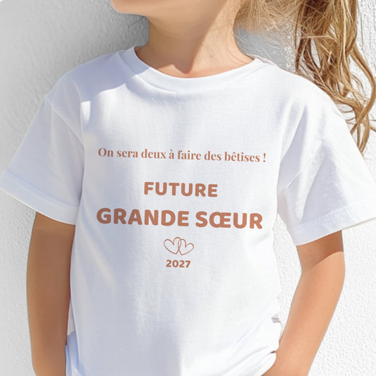 T-shirt enfant blanc future grande sœur, motif terracotta « on sera deux à faire des bêtises » avec deux cœurs entrelacés