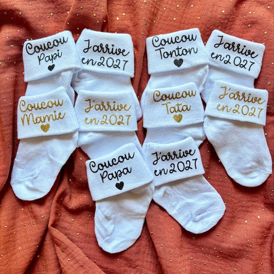Chaussettes bébé personnalisées annonce grossesse - messages Coucou Tata, Tonton, Papi, Mamie, Papa et J'arrive en 2027 en flex pailleté noir et doré