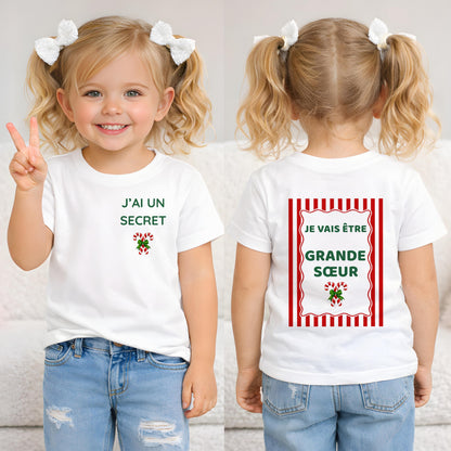 Deux fillettes portant le tee-shirt annonce grossesse de Noël, avant « J'ai un secret » et dos « Je vais être Grande Sœur »