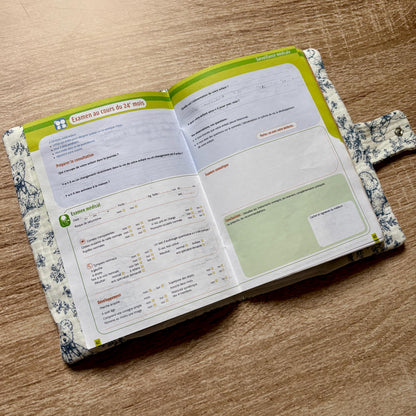 Protège carnet de santé en gaze de coton motif toile de Jouy oursons ouvert, avec le carnet de santé glissé à l'intérieur et la patte à bouton pression