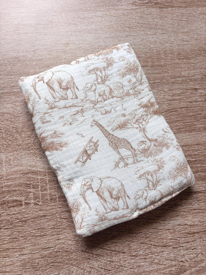 Dos du protège carnet de santé beige molletonné en gaze de coton, motif toile de Jouy Safari avec girafe, éléphants et avion ancien sur fond écru