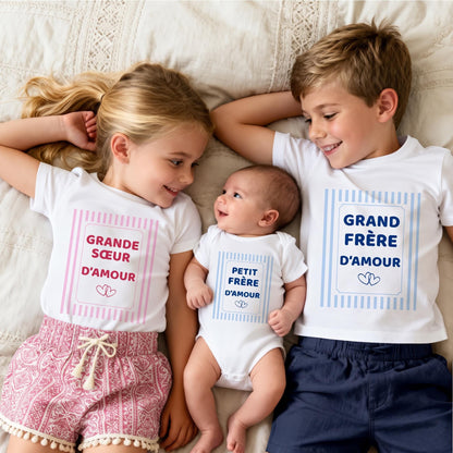 Trio de frères et sœurs allongés : t-shirt Grande sœur d'amour à rayures roses, body Petit frère d'amour et t-shirt Grand frère d'amour à rayures bleu ciel